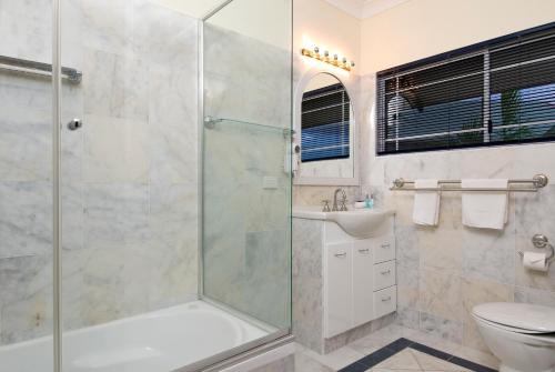 Tinaroo迪纳鲁湖度假酒店的带淋浴、盥洗盆和卫生间的浴室