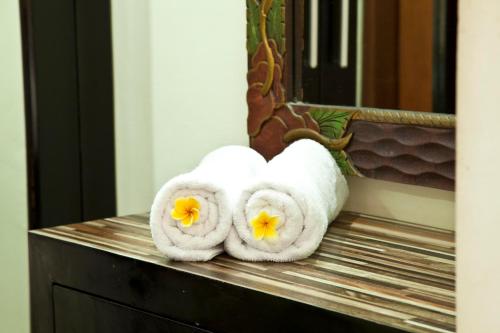 库塔捷鹏巴厘岛酒店的镜子前的柜台上摆放着几条毛巾