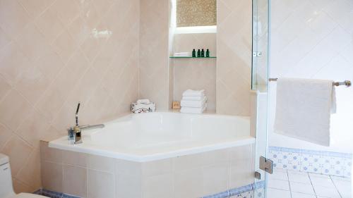 安平区有约欧风的白色的浴室设有浴缸和淋浴。