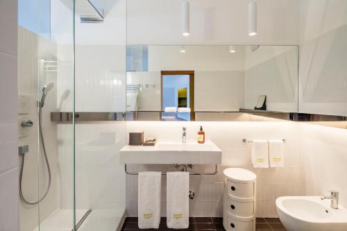 卡尔达罗Seehotel Ambach的白色的浴室设有水槽和淋浴。