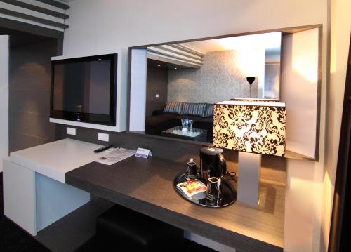 鲁塞里加大酒店的客房设有一张带电视和台灯的书桌。