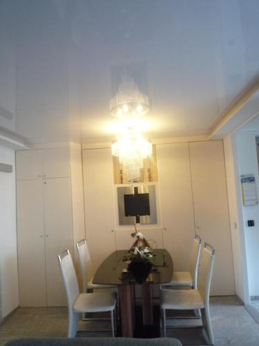 汉诺威拉特泽私人公寓的一间带桌椅和吊灯的用餐室