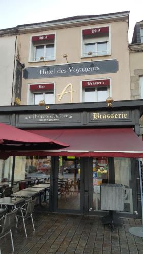 马耶讷Hotel des Voyageurs的大楼前有红色遮阳篷的餐厅