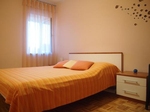 比利切Holiday Home Oliva的一间卧室配有带橙色床单的床和窗户。