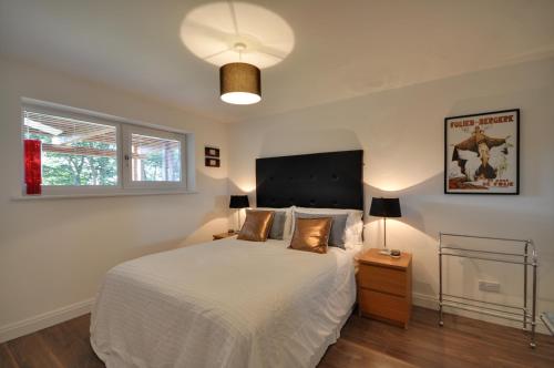 曼彻斯特The Garden Apartment, Near Airport & City的卧室配有白色大床和灯