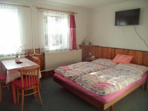 贝内茨科Benecko 131的卧室配有1张床、1张桌子和1张桌子以及椅子。