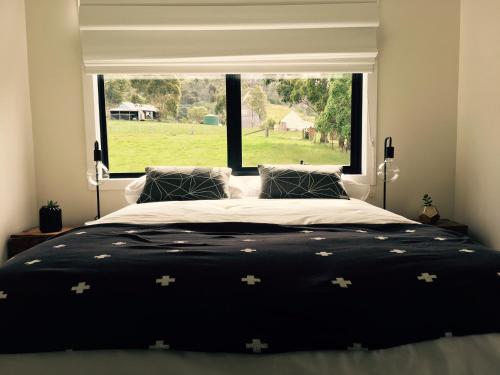 Buckland图安姆雷农庄的一间卧室设有一张大床和大窗户