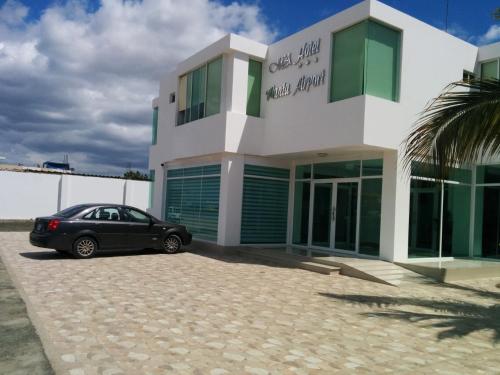 曼塔Manta Airport Hotel的停在大楼前的一辆黑色汽车
