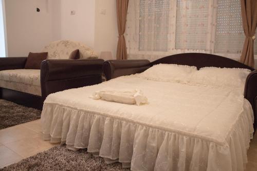 尼克希奇Apartments Matijašević的卧室配有一张白色的大床和一张沙发。