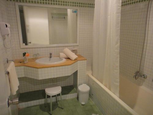 莫纳斯提尔Chiraz Club - Families Only的一间带水槽、浴缸和镜子的浴室