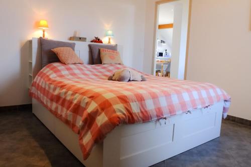 尚普索地区圣博内Appart'hôtel "Le Garage"的一间卧室配有一张床,床上放着一只狗