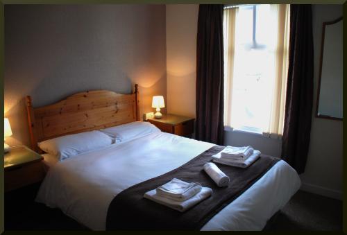 布莱克浦维也纳酒店 的一间卧室配有一张大床和毛巾