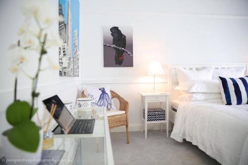 奥兰治桑普森 - 橙色度假屋的一间卧室配有一张床和一张带笔记本电脑的书桌