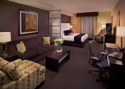 迈阿密Best Western Plus Miami Intl Airport Hotel & Suites Coral Gables的酒店客房设有一张沙发和一张床