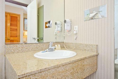 绿湾绿湾贝斯特韦斯特酒店和会议中心的浴室水槽、吹风机和镜子