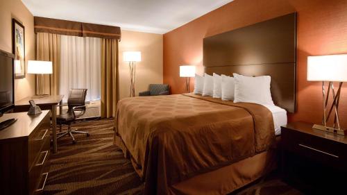 Hornell枫叶城市贝斯特韦斯特酒店的酒店客房设有一张大床和一张书桌。