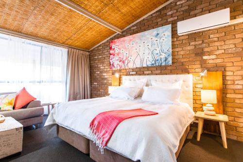 莫韦尔法纳姆阁餐厅汽车旅馆的一间卧室设有一张大床和砖墙