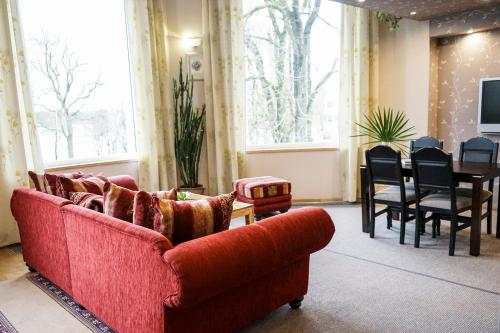 德鲁斯基宁凯塞纳西斯帕斯塔斯旅馆的客厅配有红色的沙发和桌子
