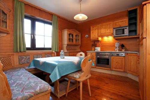 米特尔巴赫Haus W5 - DorfResort Mitterbach的厨房配有一张桌子,上面有蓝色的桌布