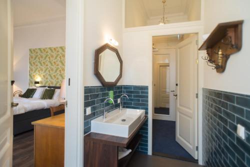 登博斯布洛韦波夫精品酒店的一间带水槽、床和镜子的浴室