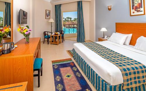 赫尔格达夏威夷水上花园度假酒店 - 仅限家庭和夫妇的酒店客房设有一张大床和一张书桌。
