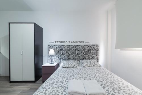 马德里Apartamentos Arapiles的白色卧室配有床和镜子