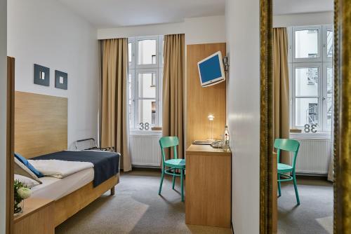 柏林38酒店（原施彻恩维特酒店）的酒店客房,配有一张床、一张桌子和椅子