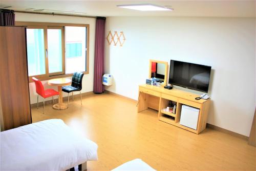 济州市萨姆达旅舍的客厅配有电视和桌椅