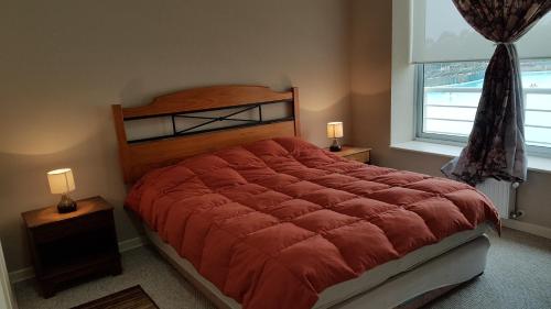 阿尔加罗沃Laguna Bahia Velero的一间卧室配有一张大床和红色的被子