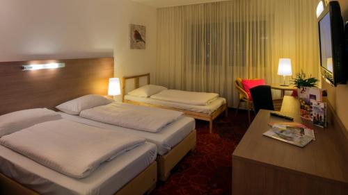 施托克劳凯瑟拉斯特酒店的酒店客房配有两张床和一张书桌
