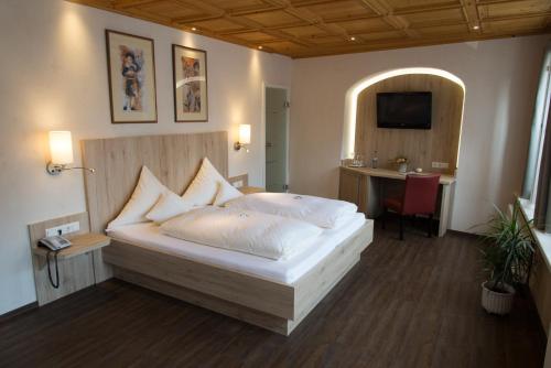 丁克尔斯比尔杜特斯彻斯豪斯酒店的一间卧室配有一张床、一张书桌和一台电视