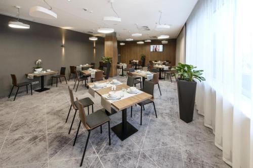 博莱斯瓦维茨Hotel Centrum的一间在房间内配有桌椅的餐厅