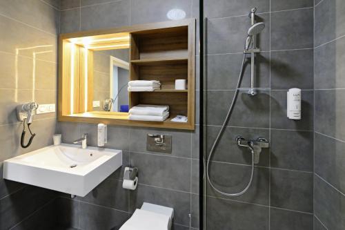 博莱斯瓦维茨Hotel Centrum的带淋浴、盥洗盆和卫生间的浴室