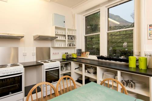 巴特米尔巴特米尔国际青年旅舍的厨房配有白色家电和桌椅