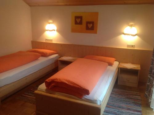圣维吉利奥Ciasa Orzun的墙上灯的房间里设有两张床