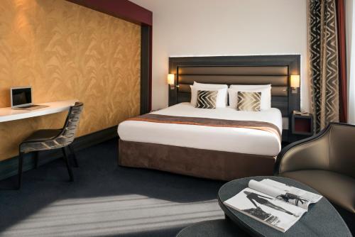 里昂里昂中央美居酒店 - 火车东站店 的配有一张床和一张书桌的酒店客房