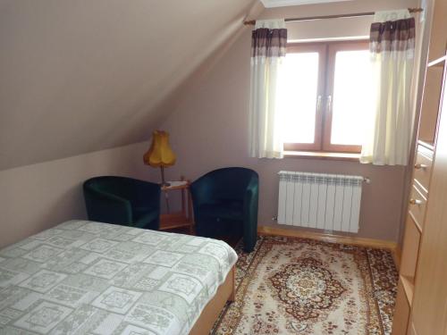 NarewkaU Witalisa的一间卧室配有两把椅子、一张床和窗户