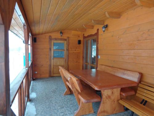 NarewkaU Witalisa的一间带木桌和长凳的用餐室