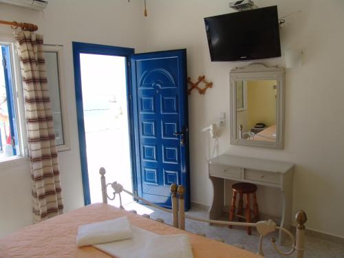 伊奥斯乔拉Ios Pelagos的一间卧室设有蓝色的门和镜子