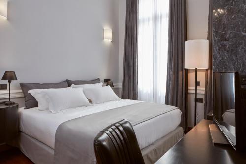 雅典齐勒精品酒店的卧室设有一张白色大床和一扇窗户。