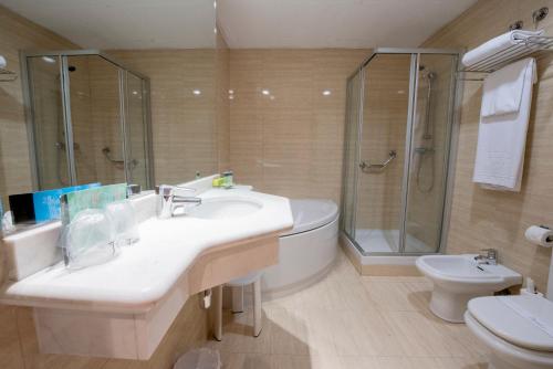 巴塞罗那西尔肯圣格瓦西酒店的一间带水槽、淋浴和卫生间的浴室