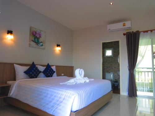 奈扬海滩Winrisa Place的卧室配有白色的床和毛巾
