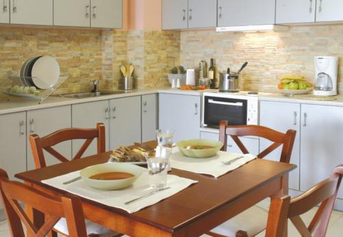 卢特拉艾季普苏海上客房&别墅公寓式酒店的厨房配有木桌和2个碗