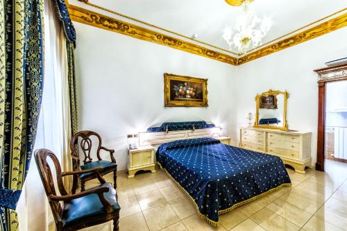 伊格莱西亚斯Euro Hotel Iglesias的一间卧室配有蓝色的床和椅子