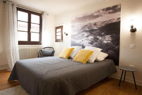 凯泽贝尔Gîte L'Atelier的一间卧室配有一张带两个黄色枕头的床