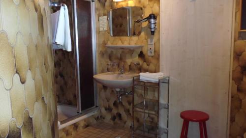 纳瑟尔文勒Landhaus Krinnenspitze的一间带水槽、镜子和凳子的浴室