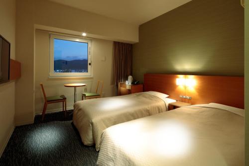 福山福山闪耀酒店的酒店客房设有两张床和窗户。