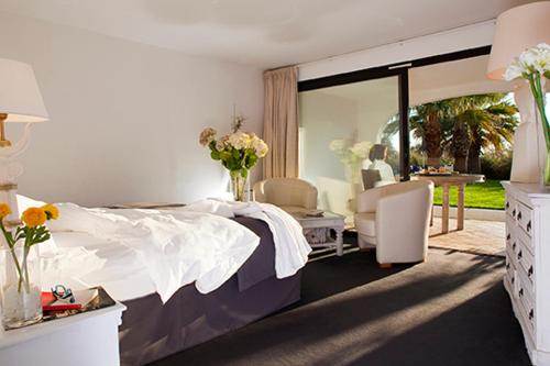 圣马迪拉莫曼吉欧矿泥温泉酒店的卧室配有一张床和一张桌子及椅子