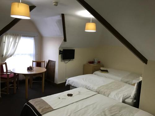 戈斯波特A Gosport Inn的客房设有两张床、一张桌子和一扇窗户。