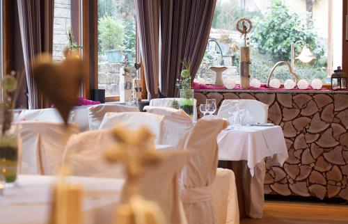 本斯海姆珀斯图本餐厅酒店的用餐室配有白色的桌子和白色的椅子